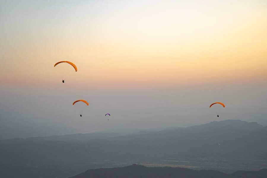 Paragliders over Bir at sunset