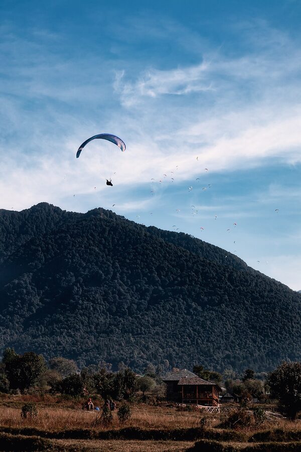 A gaggle of paragliders in the air above Bir-Billing in Himachal Pradesh