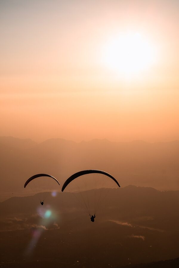 Paragliders in the late afternoon light over Bir village