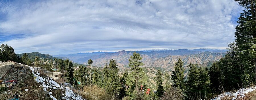 Panoramic view from Chail across the forested ridges of the sanctuary towards distant Himalayan peaks.