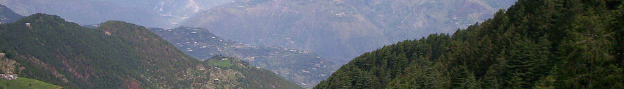 Dalhousie hill station seen from a high vantage point with deodar forest and red-roofed cottages.