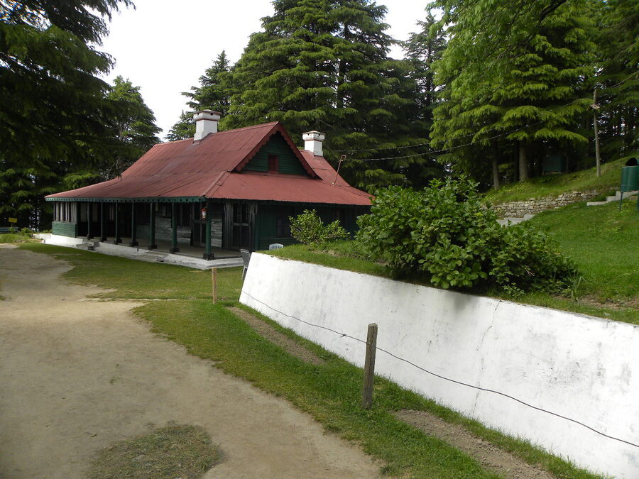 The entrance gate of Kalatop Wildlife Sanctuary in Chamba district with a forest road leading inside.