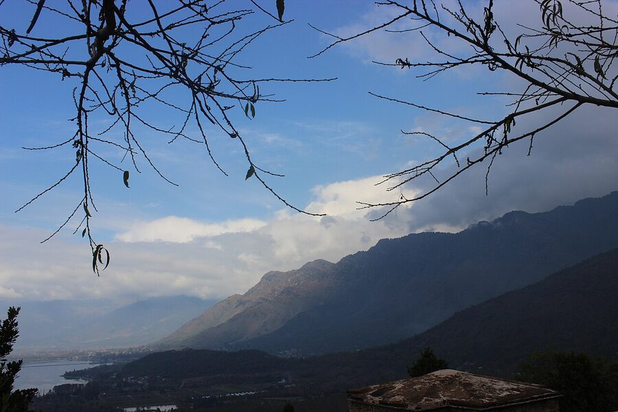 The Pir Panjal mountain range with snow-capped peaks visible across a forested valley.