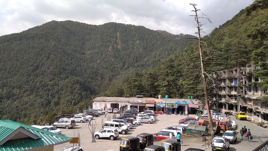 The McLeod Ganj bus stand with parked buses and travellers, Himachal Pradesh.