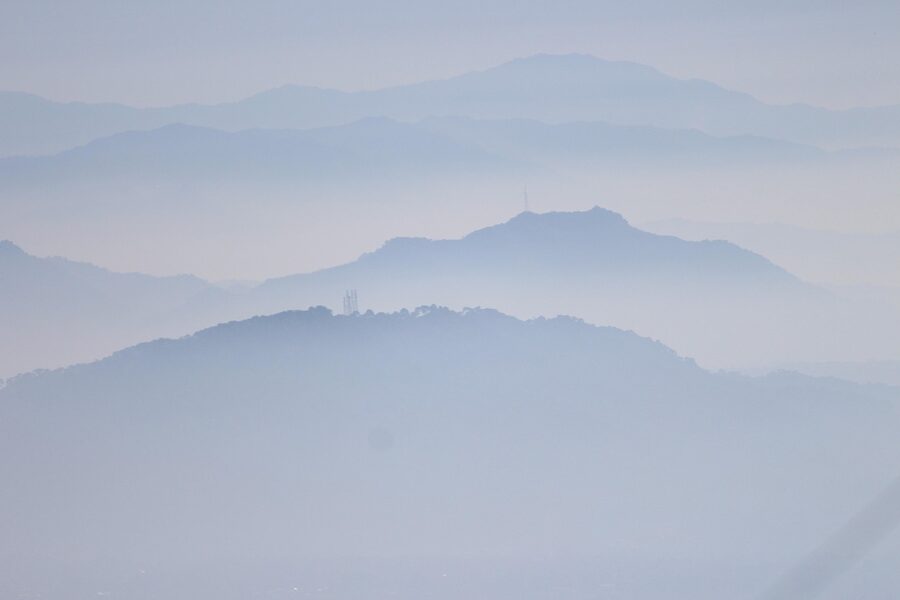 A foggy view of McLeod Ganj and the surrounding hills with mist rolling through the valley.