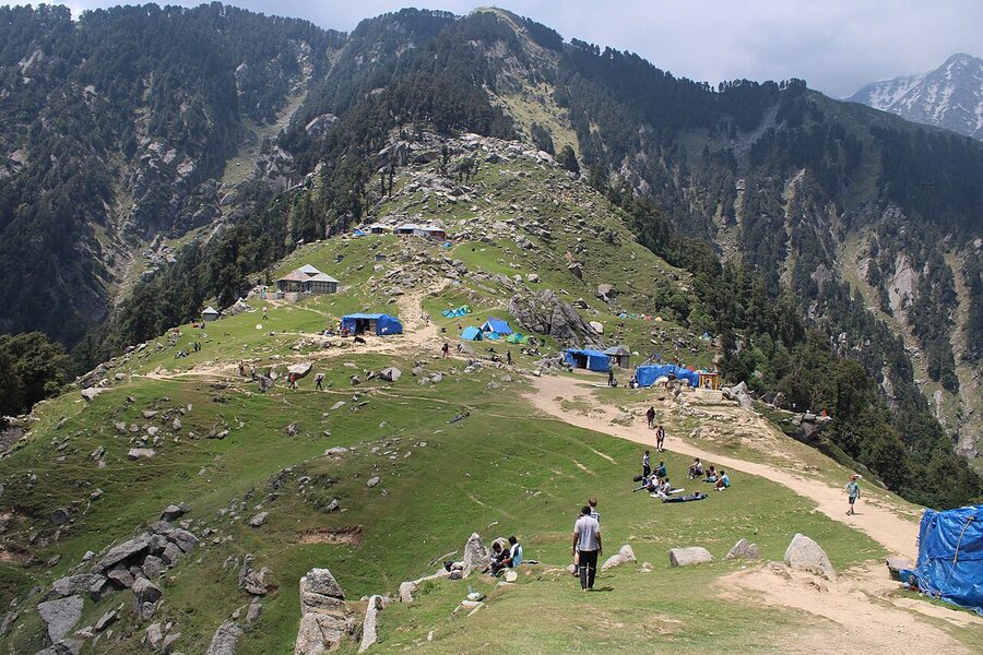 The grassy ridge of Triund hill with views of the Dhauladhar range, Himachal Pradesh.