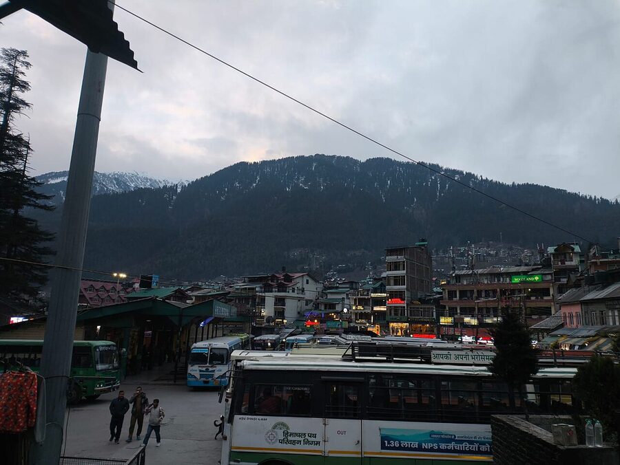 Manali bus stand with coaches on a mountain road