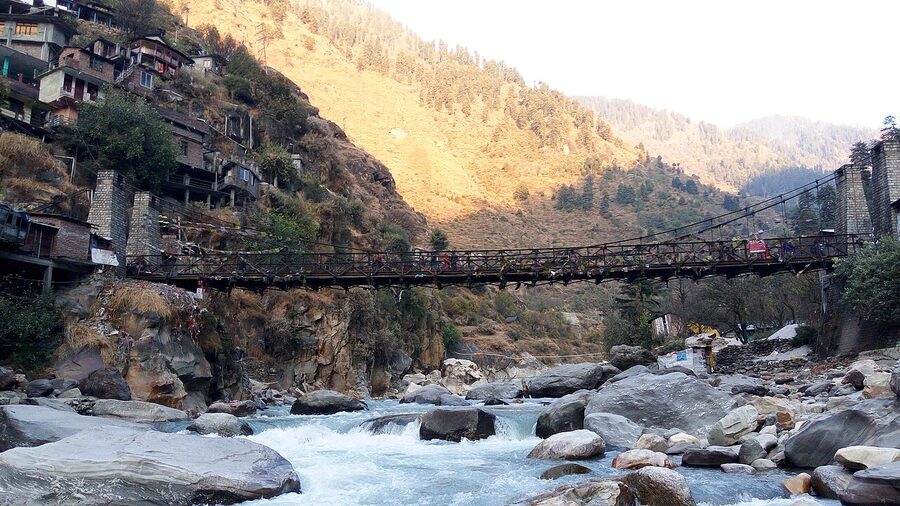 The pedestrian bridge across the Parvati river at Manikaran with the gurudwara visible.