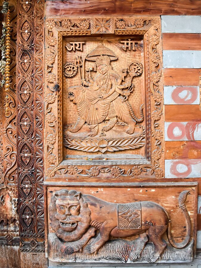 Wood-carved lion ride at the Bekhli temple, Kullu — example of traditional Kullu temple carving.