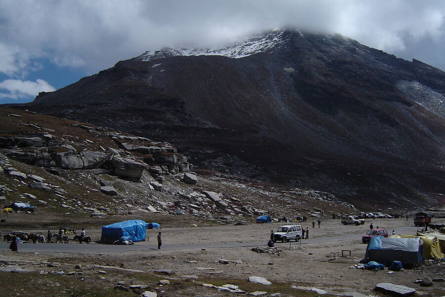 The road approaching Rohtang Pass with snow on the slopes