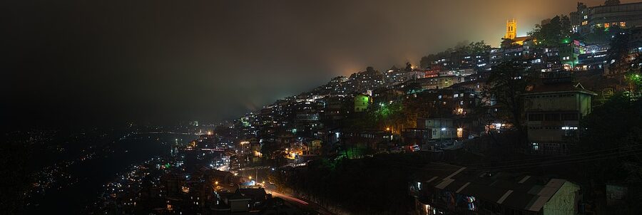 Shimla at night with lights of the hill town glowing across the ridges.